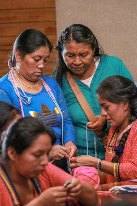 a group of women working on bracelets