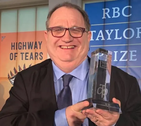 Dr Mark Bourrie holding an award